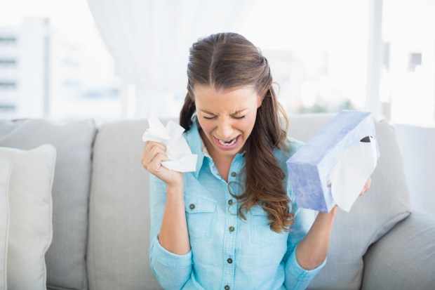 Depressed woman crying sitting on sofa